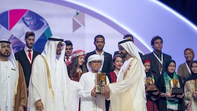 Sheikh Mohammed bin Zayed, Crown Prince of Abu Dhabi and Deputy Supreme Commander of the UAE Armed Forces, second left, and Sheikh Mohammed bin Rashid, Vice President and Ruler of Dubai, right, present an award to a winner, during the Sheikha Fatima bint Mubarak Awards for Excellence and Social Creativity, at Emirates Palace. They are seen with Ali bin Salem Al Kaabi, Director of the Office of the Minister of Presidential Affairs, and Chairman of the Board of Trustees of the Family Development Foundation, left. Mohamed Al Hammadi / Crown Prince Court - Abu Dhabi
