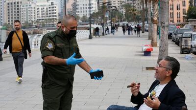 A municipal police officer, left, orders a man to leave the corniche, or waterfront promenade, along the Mediterranean Sea in Beirut. AP Photo
