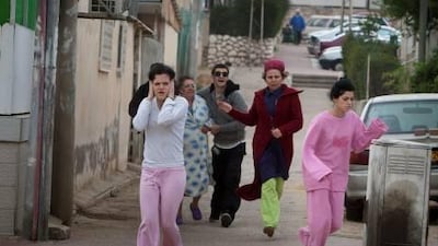 Israelis run to take cover in a shelter during a Palestinian rocket attack on the southern Israeli city of Beersheva, about 40 kilometres from the Gaza Strip, yesterday.