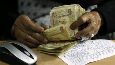 A cashier counts Indian rupee bank notes in Allahabad, India. AP Photo