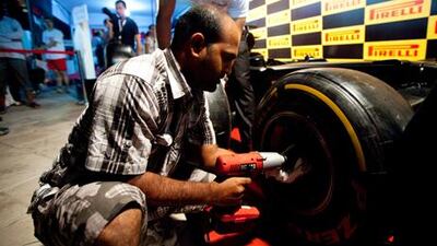 A man tries his hand at changing a F1 tyre in the Pirelli booth at Abu Dhabi Corniche during Abu Dhabi Grand Prix weekend.