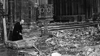 The verger of Westminster Abbey examines the wreckage of the magnificent canopy, lying broken in a pool of water during the Second World War in 1941