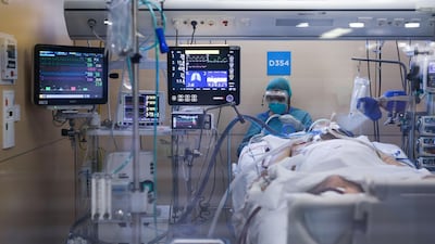 A healthcare worker wearing a protective suit attends to a coronavirus patient at the Intensive Unit Care (ICU) of the Vall d'Hebron Hospital in Barcelona. AFP