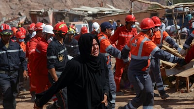 A woman grieves as rescue workers carry her husband's body from rubble in Talat N'Yaaqoub. Reuters