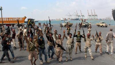 Fighters loyal to the Yemeni government flash victory signs after taking control of the port in Aden on January 4, 2016. Saleh Al Obeidi / AFP