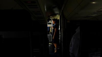 Dubai, United Arab Emirates - August 01 2013 - An airhostess waits for instructions to exit the new Rotana Jet after it landed at Dubai International Airport. It that operates as a commuter flight daily between Abu Dhabi and Dubai. Four National reporters raced from Abu Dhabi to Dubai using various modes of transport to see which vehicle took the least time between two cities. (Razan Alzayani / The National)