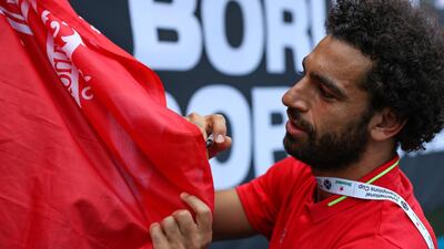 Liverpool's Mohamed Salah signs autographs following the match. Reuters