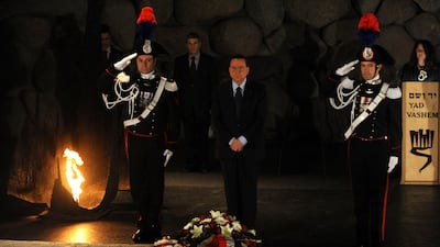 Mr Berlusconi, centre, stands solemnly after laying a wreath at the Hall of Remembrance at the Yad Vashem Holocaust Memorial in Jerusalem in 2010. AFP