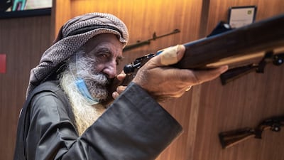 Marksman Ali Mohammad Al Shehhi checks out some rifles at the Caracal stall at Adihex. Victor Besa / The National