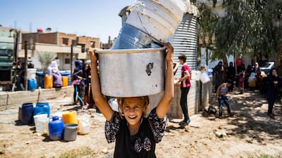 A Syrian child carries containers to collect water provided by Unicef in Al Hasaka. AFP