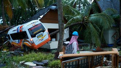 A rescue worker walks past a wrecked bus and bungalow at a resort hotel in Tanjung Lesung. Getty