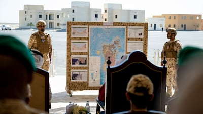 Military personnel make a presentation to guests observing the exercise
