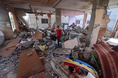 A Palestinian boy salvages items from a damaged apartment following an Israeli bombardment in Rafah on Thursday. AFP