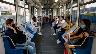 Passengers sit in between social distancing markers on the first day of train operations since the lockdown. Reuters