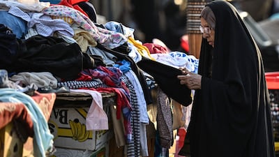 Second-hand clothes are sold at a market in Basra. Iraq's central bank devalued the dinar this month, as the country faces a deepening crisis driven by the Iran war. AFP