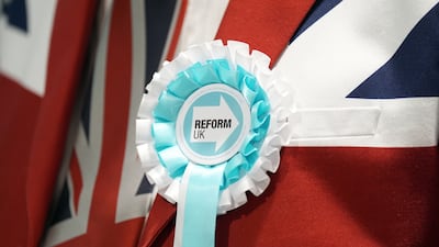 A man in a Union Jack blazer sports a Reform UK rosette as ballot papers are counted in Essex. PA