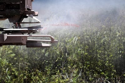 A tractor spreads a fertilizer to the soybean field in Goias, Brazil. Photo by Mateus Bonomi/Anadolu Agency via Getty Images)