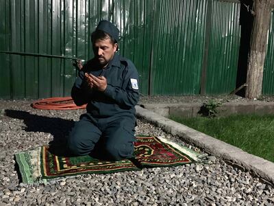 Afghan policeman Mohammad Qand prays at a check-post in central Kabul. Hikmat Noori for The National