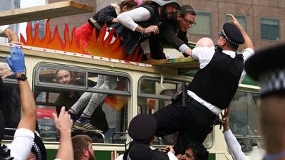 Police officers try to reach Extinction Rebellion demonstrators to remove them from the roadblock by London Bridge during a protest. Reuters