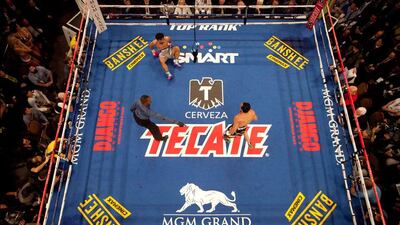Referee Kenny Bayless, left, directs Juan Manuel Marquez, right, to a corner as Manny Pacquiao sits on the mat after being knocked down by Marquez in the third round during their welterweight fight. Julie Jacobson / AP Photo