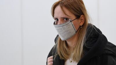 A woman wearing a face mask arrives at Heathrow Airport in London, Britain, 24, January 2020. The UK is to begin monitoring direct flights from China to stem the spread of the coronavirus in Britain. EPA