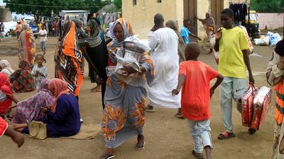 Sudanese, displaced from the town of Sinjah, receive humanitarian aid at their makeshift camp in the eastern city of Gedaref on August 22, 2024. AFP