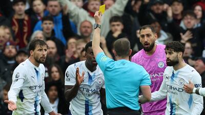 Referee Peter Bankes shows a yellow card to Manchester City defender Marc Guehi. AFP