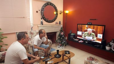 Two men watch Cuban president Raul Castro’s speech to announce an agreement to ‘reestablish diplomatic relations’ with the US in Havana on December 17, 2014. Ernesto Mastrascusa / EPA