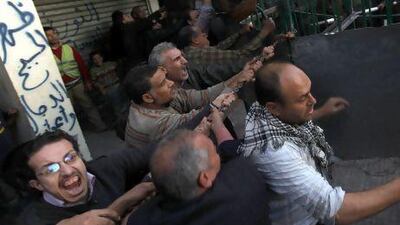 Anti-Morsi protesters attempt to remove a barrier on a road leading to the presidential palace in Cairo on Tuesday.