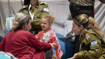 Yahel Shoham, three, and Sharon Avigdori, released Israeli hostages, interact shortly after their arrival in Israel. Reuters