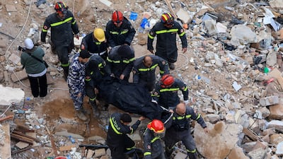 Rescue workers remove a body from under the rubble. Reuters