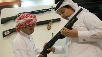 Boys take a closer look at a rifle on display at the Browning stall. Ravindranath K / The National