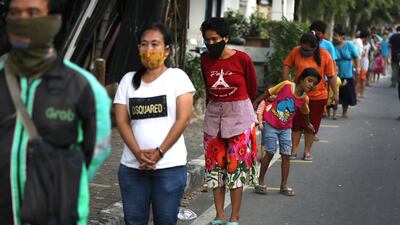 People stand on marked spots to practice social distancing in Jakarta, Indonesia. AP Photo
