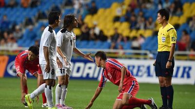 So Kyong-Jin, centre, of North Korea stands up as Humam Tareq Faraj Faraj, third from left, of Iraq contests a foul during their men's semifinal football match at the Asian Games in Incheon on September 30, 2014. AFP PHOTO / Ed Jones