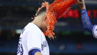 TORONTO, CANADA - MAY 4: Russell Martin #55 of the Toronto Blue Jays has Gatorade dumped on him by Darwin Barney #18 after hitting a game-winning RBI single during MLB game action against the Texas Rangers. Tom Szczerbowski / Getty Images / AFP