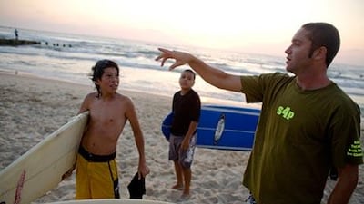 Arthur Rashkovan talks with young Arab-Israeli surfers at a surf session and bonfired sponsored by Surfers 4 Peace at Jaffa Beach in Tel Aviv.