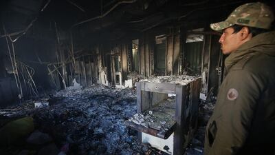 A man inspects the burnt entrance of the US embassy. AFP