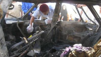 An Iraqi police officer inspects the scene of a car bombing in Dujail, 80km north of Baghdad, in Iraq, on Sept 13 2008. The car bomb, which exploded on Sept 12 2008, ripped through a crowded commercial district in Dujail.
