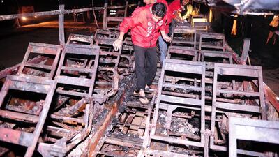 Pakistani volunteers search for victims inside a burnt out passenger bus after it collided with an oil tanker along the Super Highway near Karachi. At least 57 people were killed when an oil tanker apparently speeding in the wrong direction down a Pakistan road crashed into a passenger bus, igniting a fierce blaze, police said. Asif Hassan / AFP