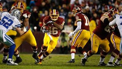 Washington Redskins running back Alfred Morris, centre, runs through the Dallas Cowboys line.