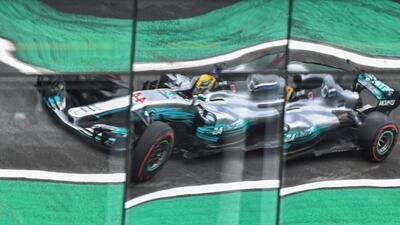 Mercedes driver Lewis Hamilton is reflected on windows as he powers his car during the Brazilian Formula One Grand Prix third practice session in Sao Paulo, Brazil. Nelson Almeida / AFP Phot