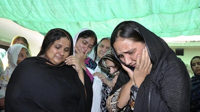 Relatives mourn over the body of Rashid Rehman, who was killed by unidentified gunmen at his residence in Multan. Reuters / May 8, 2014