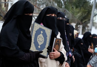 Women in Pakistan hold copies of the Quran during a protest to denounce the demonstrations in Europe. AP