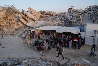 Palestinians walk amid the rubble of destroyed homes and buildings in Jabalia, northern Gaza. AP