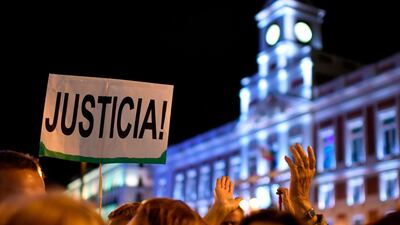 A woman holds a placard reading 'Justice' during a demonstration to mark the International Day for the Elimination of Violence Against Women. AFP/Gabriel Bouys