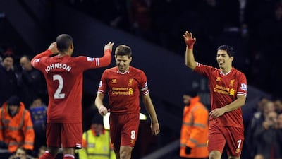 Liverpool's Luis Suarez, right, celebrates after scoring the second goal of the game with teammates Steven Gerrard, center, and Glen Johnson during their English Premier League soccer match against Norwich City at Anfield in Liverpool, England, Wednesday Dec. 4, 2013. AP Photo/Clint Hughes
