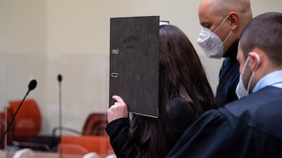 Jennifer Wenisch hides her face as she arrives in court in Munich, Germany. AP