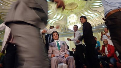 Young Afghan men dance around a groom during wedding celebrations at a wedding hall in Kabul. As Afghanistan's wedding season kicks into high gear, lawmakers are pushing for austerity, bent on taming out-of-control guest lists. Shah Marai/AFP Photo