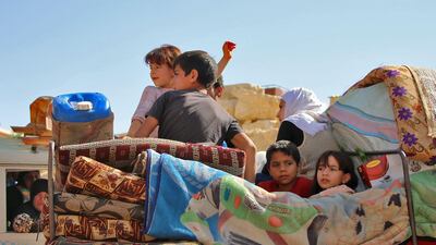 Syrian refugees children ride on a vehicle getting ready to cross into Syria from the eastern Lebanese border town of Arsal, Lebanon, on June 28, 2018. Stringer / AFP
