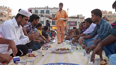 Ajman, August 7, 2011 - Al Ihsan Charity Center volunteer Kawsaor Miah sets a plate of biryani for those attending Iftar at the Ahmed Mohammad Saeed Mosque in Ajman City. (Jeff Topping/The National)